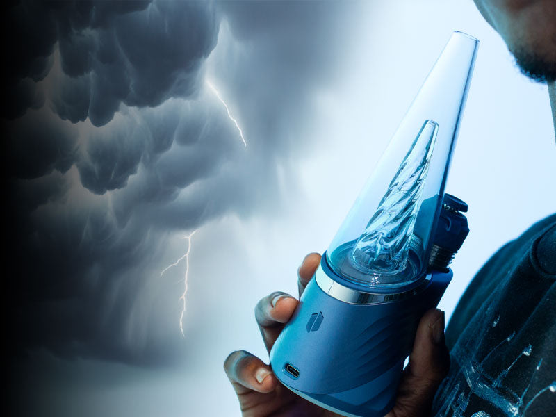 Man holding Puffco Peak Pro Storm in front of storm cloud background